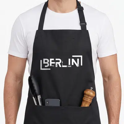 Tablier de cuisine noir avec inscription blanche BERLIN combinée à des silhouettes de tours et d'édifices emblématiques.