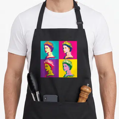 Tablier de cuisine noir avec quatre portraits colorés de la Reine d'Angleterre en style Pop Art sur fonds cyan, rose, violet et jaune.