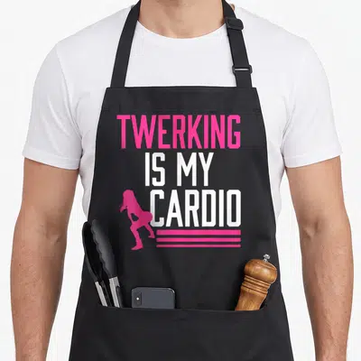 Tablier de cuisine noir avec inscription blanche Twerking Is My Cardio et silhouette rose stylisée en bas à gauche.