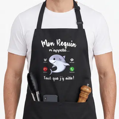Tablier de cuisine noir avec un requin cartoon et des icônes d'appel téléphonique en français.