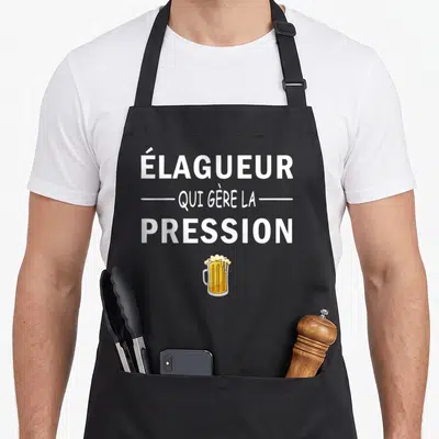 Tablier de cuisine noir avec inscription Élagueur qui gère la pression et une illustration de verre de bière doré.