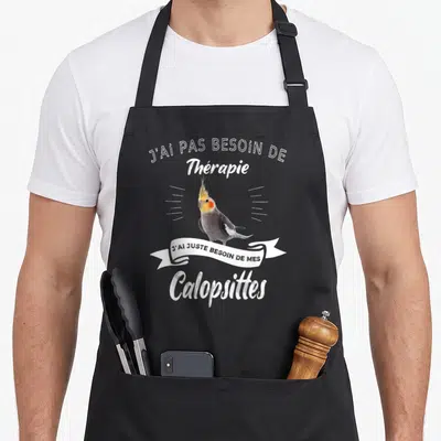 Tablier de cuisine noir avec un calopsitte gris et jaune sur fond blanc et le texte J'ai pas besoin de thérapie.