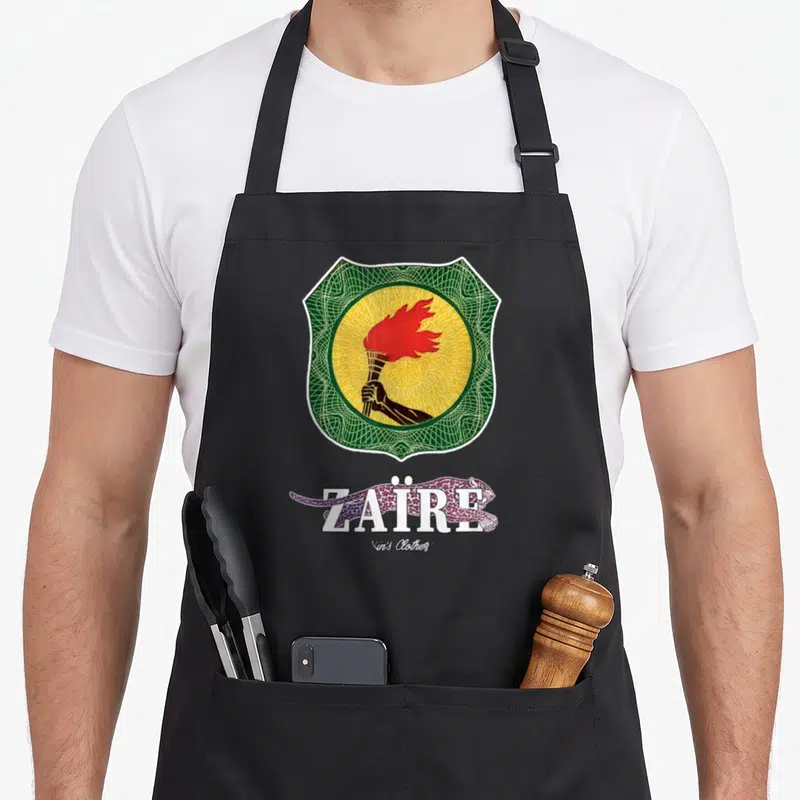 Tablier de cuisine noir avec emblème Zaïre, torche rouge, fond jaune et léopard violet en dessous.