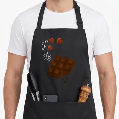 Tablier de cuisine noir avec J'aime le chocolat, une barre de chocolat croquée et trois cœurs marron flottants.