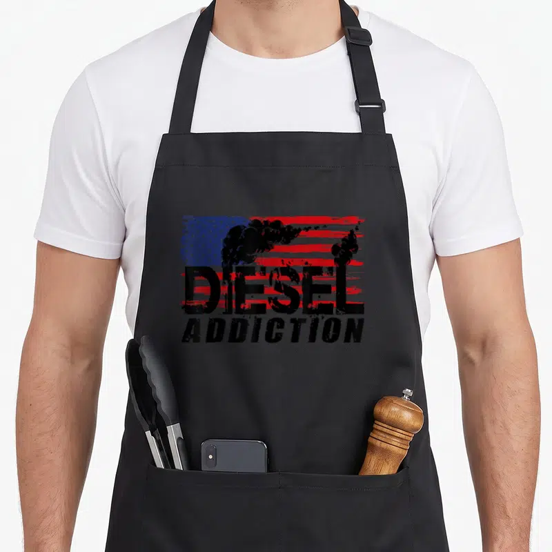 Tablier de cuisine noir avec inscription Diesel Addiction et drapeau américain stylisé en rouge, blanc et bleu avec fumée noire.