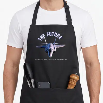 Tablier de cuisine noir avec illustration frontale d'un avion F-35 et le texte The Future en arc de cercle.