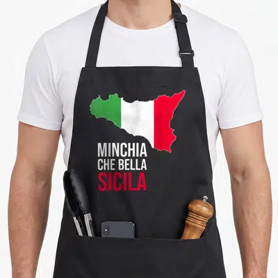 Tablier de cuisine noir avec une carte de Sicile aux couleurs du drapeau italien et un texte humoristique en blanc et rouge.