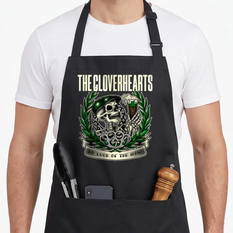 Tablier de cuisine noir avec un crâne en casquette verte tenant une bière et le texte No Luck of the Irish.