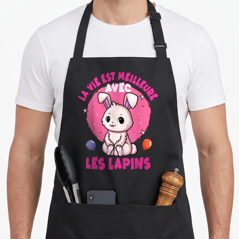 Tablier de cuisine noir avec un lapin rose assis, des étoiles et le texte la vie est meilleure avec les lapins.