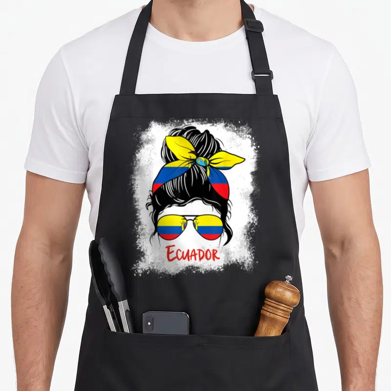 Tablier de cuisine noir avec illustration d'une femme au chignon bandé du drapeau équatorien et lunettes aux verres tricolores.
