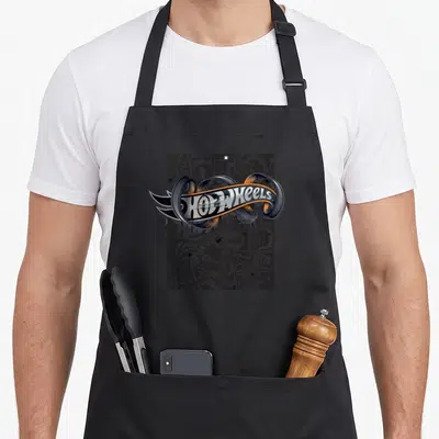 Tablier de cuisine noir avec logo Hot Wheels métallique sur fond de motifs graffiti gris et noirs répétitifs.