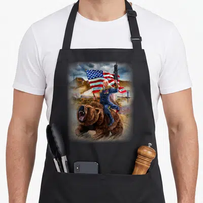 Tablier de cuisine noir avec illustration d'un homme à cheval sur un ours tenant un drapeau américain et un fusil.