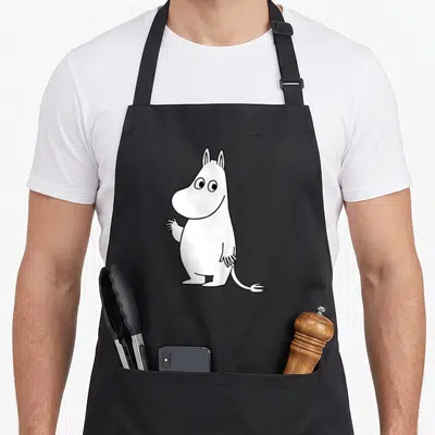 Tablier de cuisine noir avec illustration blanche de Moomintroll agitant la main droite