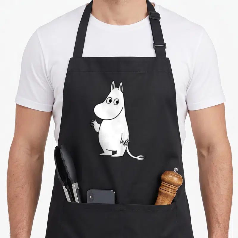 Tablier de cuisine noir avec illustration blanche de Moomintroll agitant la main droite