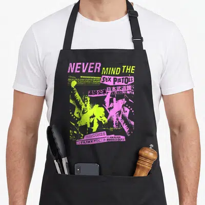 Tablier de cuisine noir avec affiche concert Sex Pistols rose jaune et texte Never Mind The Filthy Lucre