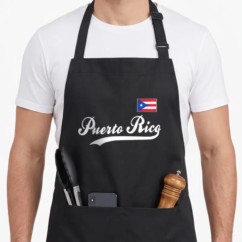 Tablier de cuisine noir avec l'inscription Puerto Rico en blanc et un petit drapeau coloré en haut à droite.