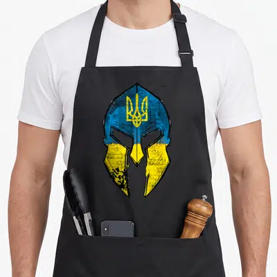 Tablier de cuisine noir avec illustration casque spartate aux couleurs bleu et jaune de l'Ukraine et trident central.