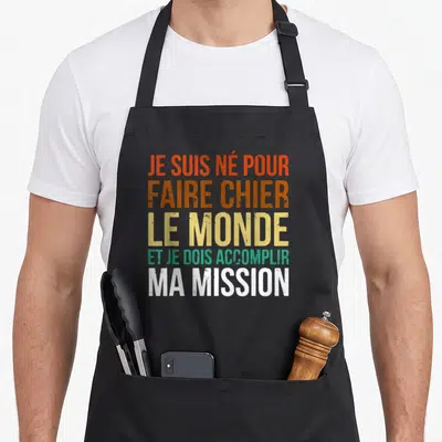 Tablier de cuisine noir avec inscription multicolore Je suis né pour faire chier le monde et je dois accomplir ma mission.