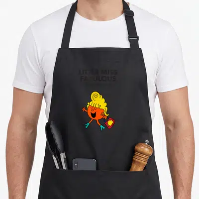 Tablier de cuisine noir avec Little Miss Fabulous aux cheveux blonds portant un sac rose à étoile jaune