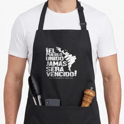 Tablier de cuisine noir avec inscription blanche Jamais sera vaincu et silhouette stylisée du continent sud-américain.