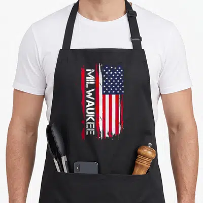 Tablier de cuisine noir avec inscription Milwaukee verticale et motif drapeau américain rouge blanc bleu dégradé.