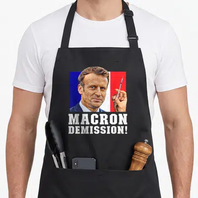 Tablier de cuisine noir avec portrait stylisé tenant une seringue et texte blanc Macron démission.