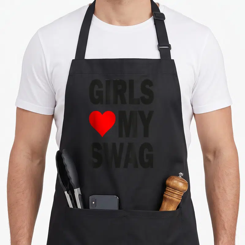 Tablier de cuisine noir avec inscription Girls My Swag et un cœur rouge vif au centre.