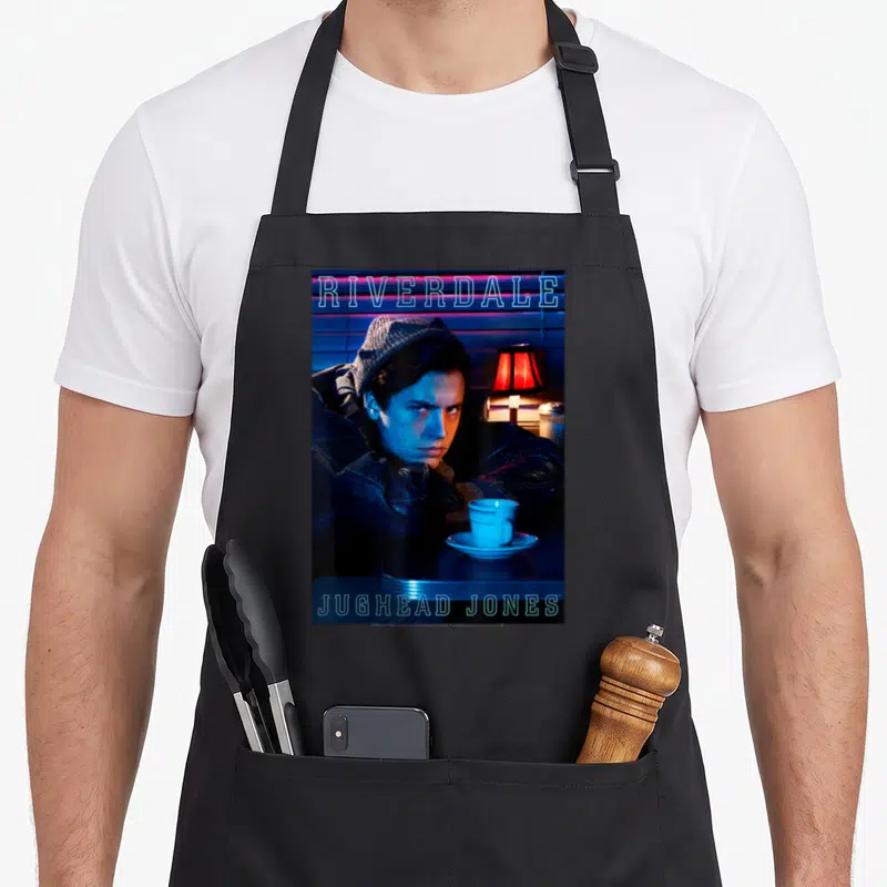 Tablier de cuisine noir avec Jughead Jones au Pop's Diner, néons bleus et lampe rouge sur fond sombre.