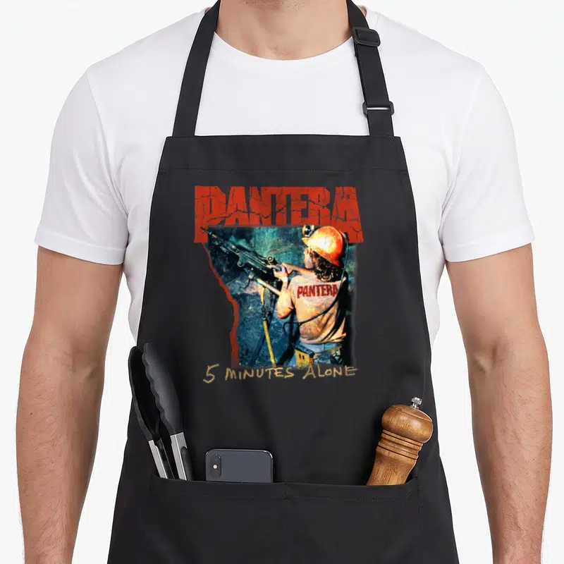 Tablier de cuisine noir avec illustration d'un mineur portant un casque et tenant une arme sous le logo Pantera.