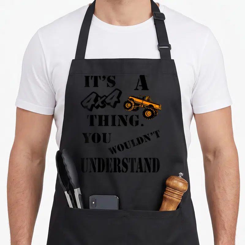 Tablier de cuisine noir avec l'inscription It's a 4x4 thing you wouldn't understand et un monster truck orange.