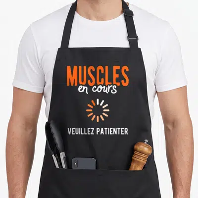 Tablier de cuisine noir avec inscription Muscles en cours et icône de chargement orange.