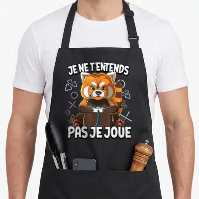 Tablier de cuisine noir avec illustration d'un renard roux tenant une manette et le texte Je ne t'entends pas je joue.