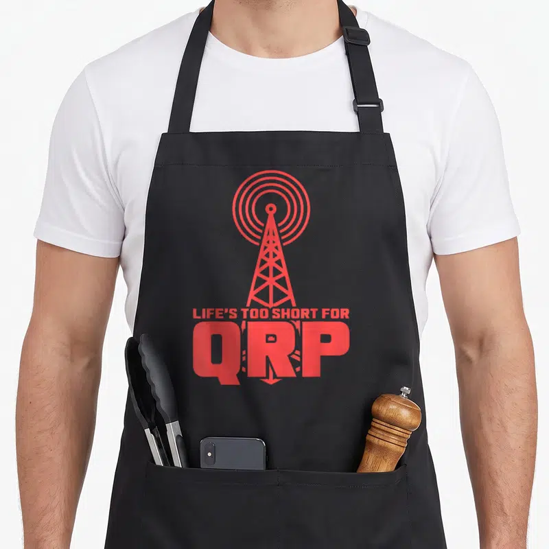 Tablier de cuisine noir avec illustration d'antenne émettant des ondes et texte Life's Too Short for QRP en rouge.