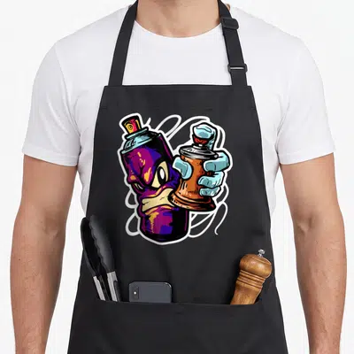 Tablier de cuisine noir avec illustration d'une main tenant une bombe aéroso et une bombe fat cap au design graffiti coloré.