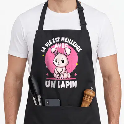 Tablier de cuisine noir avec un lapin rose assis et le texte La vie est meilleure avec un lapin.