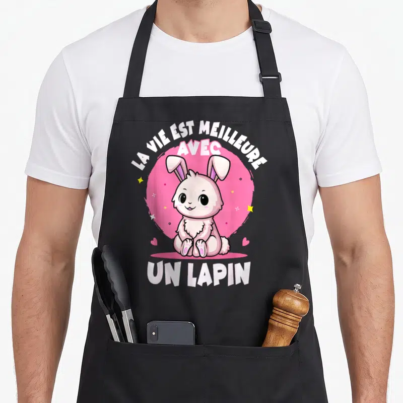 Tablier de cuisine noir avec un lapin rose assis et le texte La vie est meilleure avec un lapin.