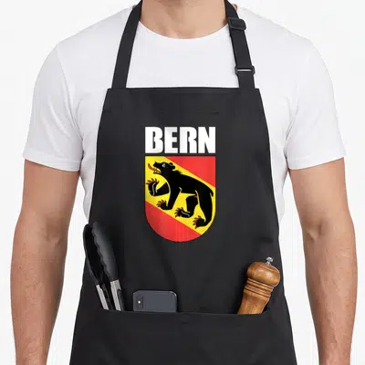 Tablier de cuisine noir avec les armoiries de Bern représentant un ours noir sur fond jaune et rouge.