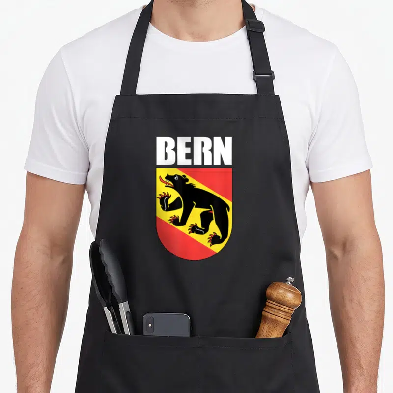 Tablier de cuisine noir avec les armoiries de Bern représentant un ours noir sur fond jaune et rouge.