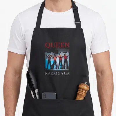 Tablier de cuisine noir avec illustration du groupe Queen et le texte Radio Ga Ga imprimé en bas.