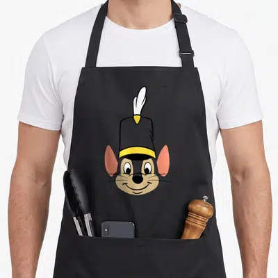 Tablier de cuisine noir avec le visage souriant de Timothy Q Mouse portant son chapeau à plume jaune et blanche.