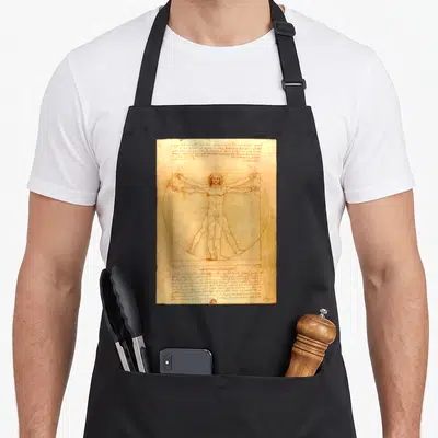 Tablier de cuisine noir avec reproduction du Vitruve Man de Léonard de Vinci sur fond parchemin vieilli.