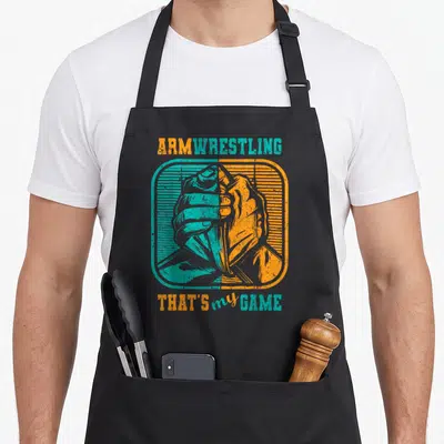 Tablier de cuisine noir avec illustration vintage d'un bras de fer bicolore turquoise et orange.