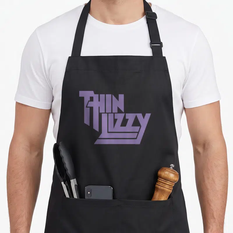Tablier de cuisine noir avec le logo Thin Lizzy imprimé en violet stylisé au centre.