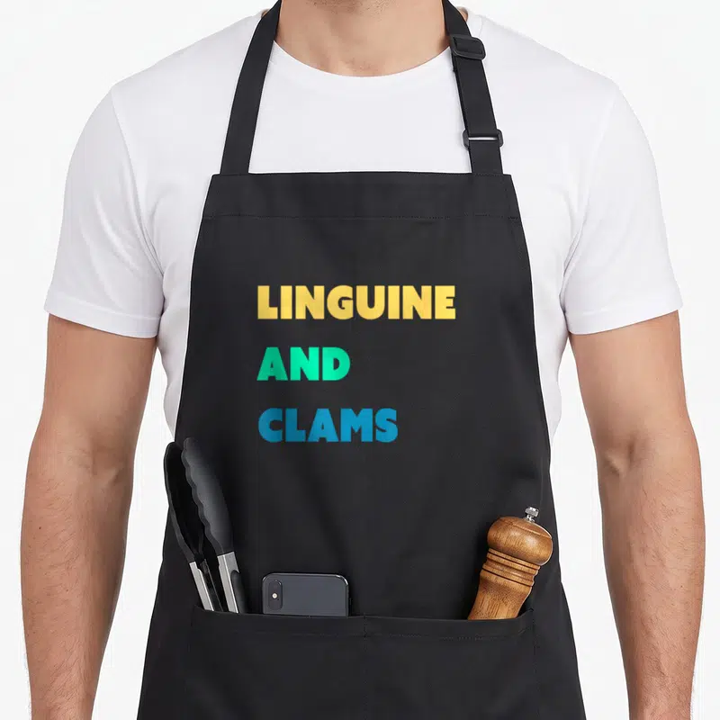 Tablier de cuisine noir avec le texte Linguine and Clams en lettres jaunes, vertes et bleues.