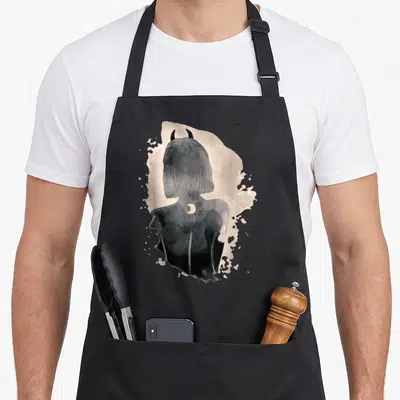 Tablier de cuisine noir avec illustration surréaliste d'une silhouette aux cornes et croissant de lune en aquarelle sombre.