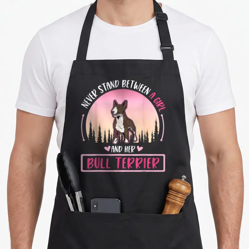 Tablier de cuisine noir avec illustration d'un Bull Terrier et texte en anglais sur fond rose.