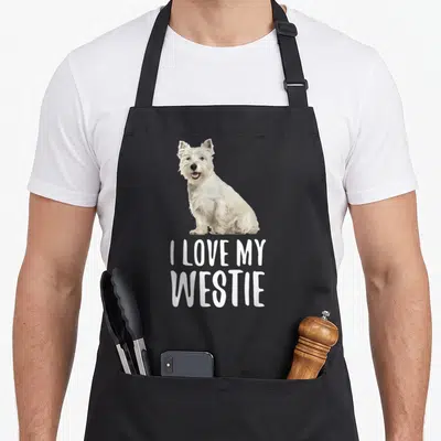 Tablier de cuisine noir avec illustration d'un Westie blanc et texte I LOVE MY WESTIE en lettres capitales blanches.