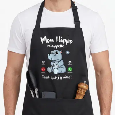 Tablier de cuisine noir avec un hippopotame cartoon et des icônes d'appel téléphonique imprimées en couleur.