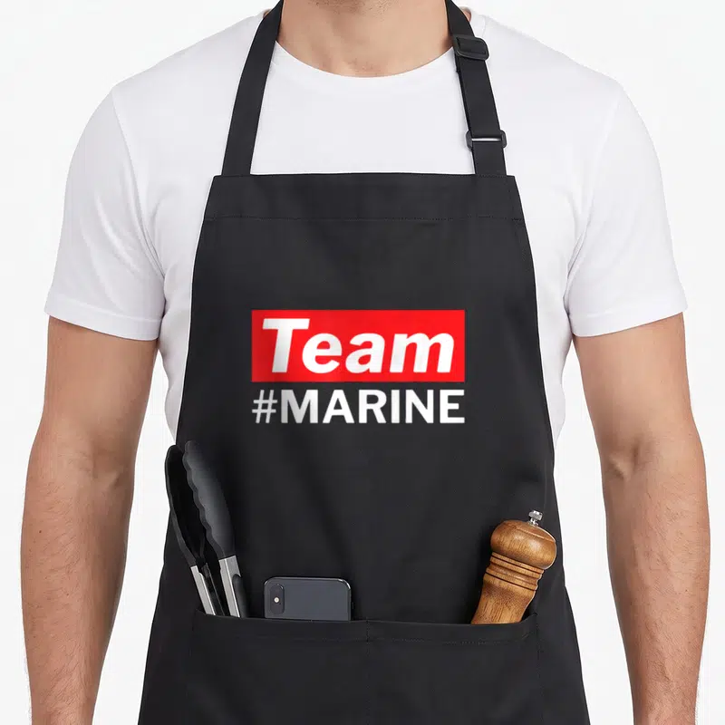 Tablier de cuisine noir avec un rectangle rouge affichant Team en blanc et #MARINE en dessous.