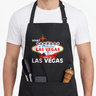 Tablier de cuisine noir avec l'enseigne lumineuse de Las Vegas et le slogan What happens in Fabulous Las Vegas Nevada stays in Las Vegas.